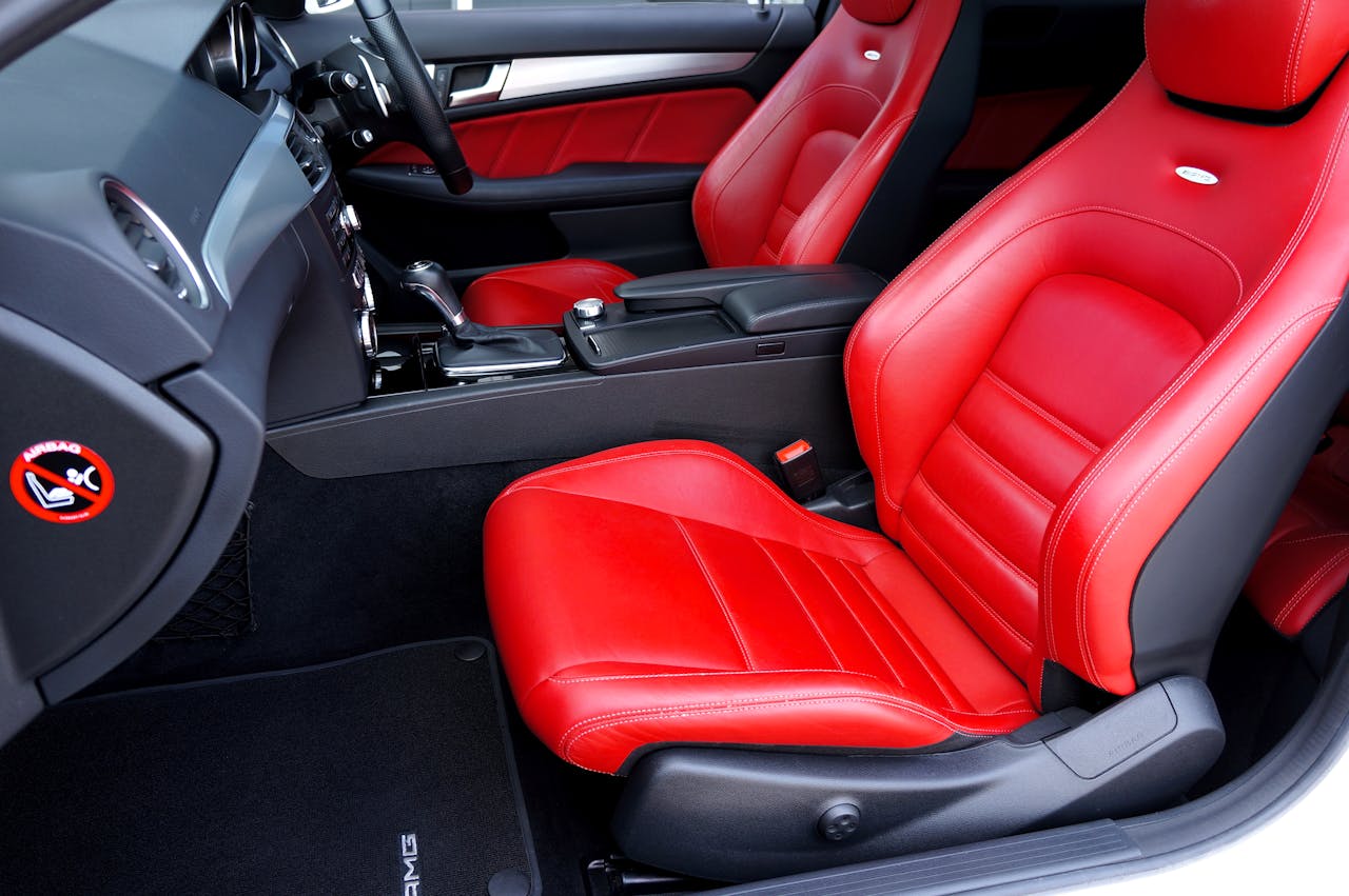 Discover a stylish car interior featuring luxurious red leather seats and a modern design.
